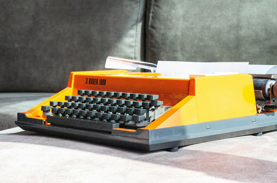 Vintage typewriter on wooden desk with scattered papers
